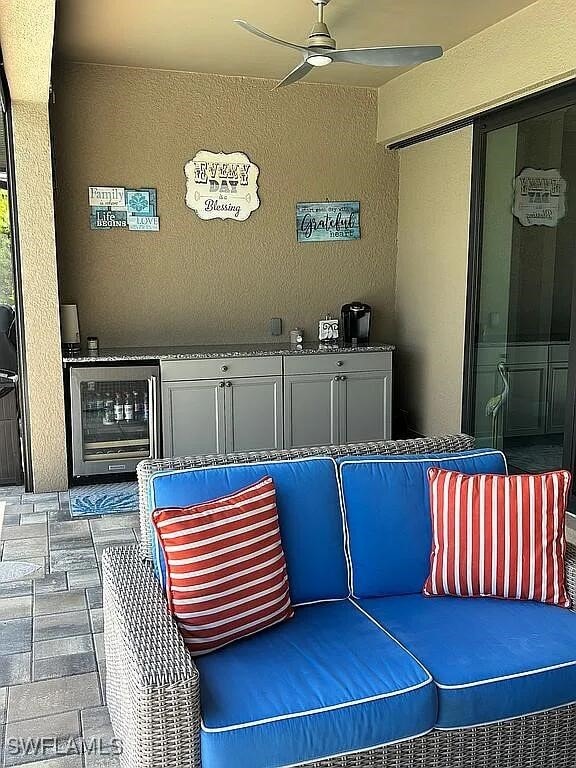 view of patio with an outdoor kitchen, wine cooler, and ceiling fan