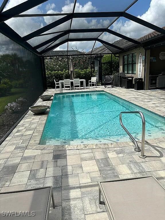 view of swimming pool with a lanai and a patio area