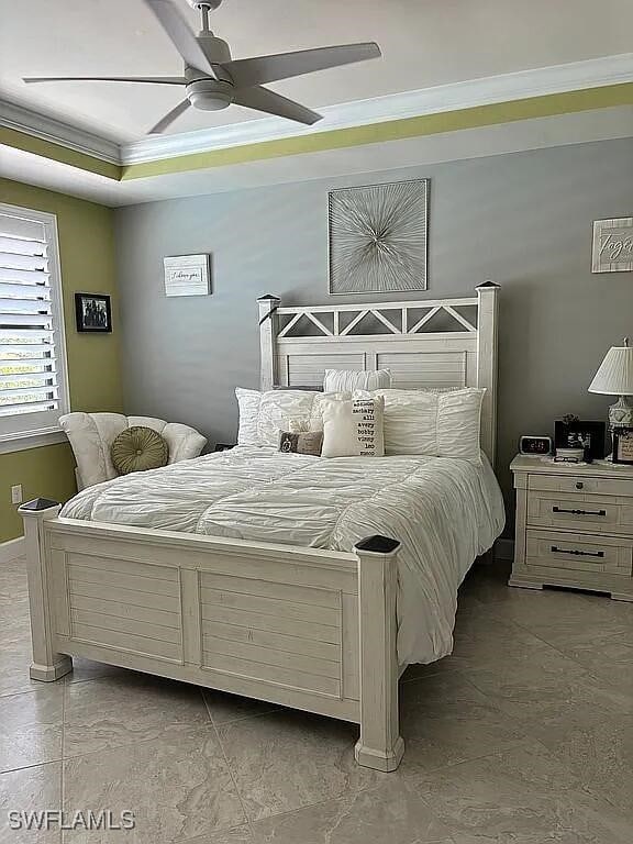 bedroom with ceiling fan, ornamental molding, and a raised ceiling