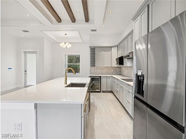 kitchen featuring backsplash, gray cabinets, stainless steel refrigerator with ice dispenser, sink, and beverage cooler