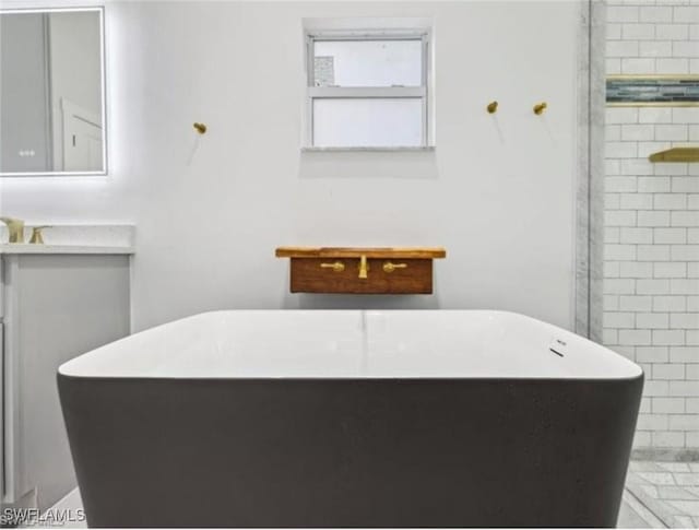 bathroom featuring vanity and a tub to relax in