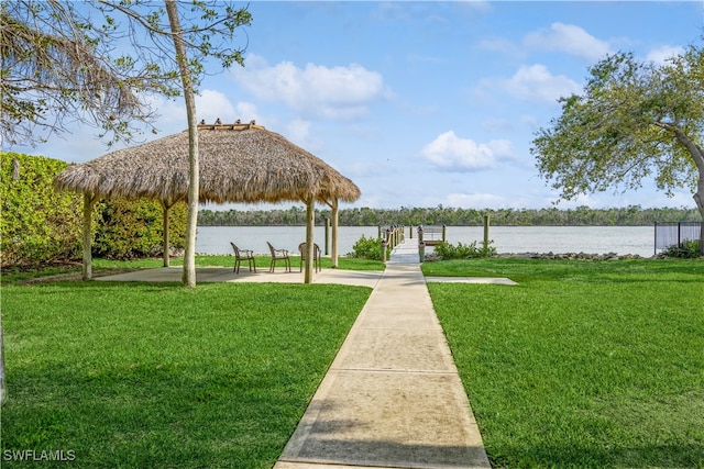 view of home's community with a gazebo, a water view, and a lawn