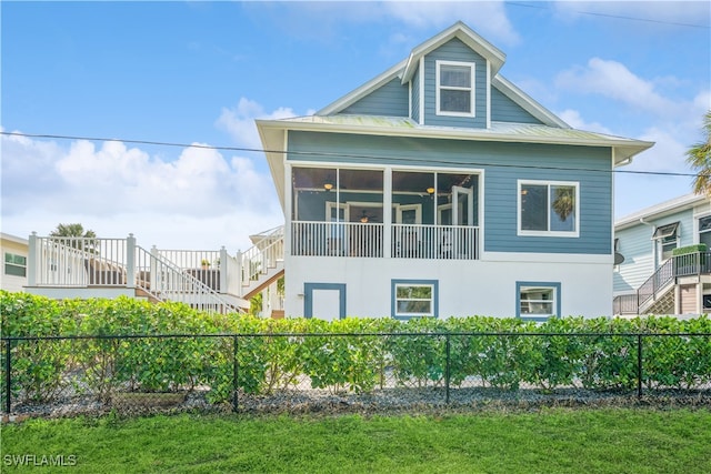 view of side of home featuring a sunroom and a yard