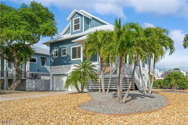 coastal inspired home featuring covered porch and a garage