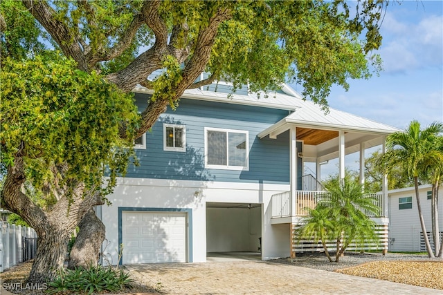 obstructed view of property featuring covered porch and a garage