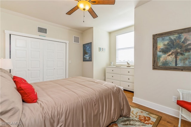 bedroom with ceiling fan, wood-type flooring, and a closet