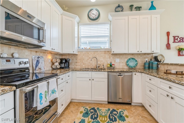 kitchen with sink, white cabinets, stainless steel appliances, and stone countertops