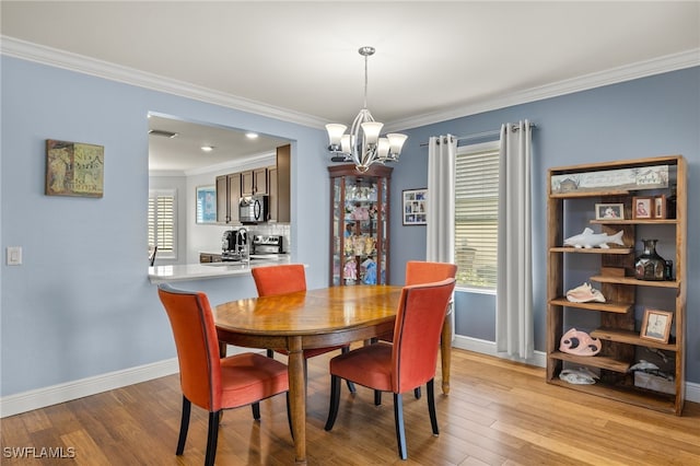 dining space featuring light wood-type flooring, a chandelier, sink, and crown molding