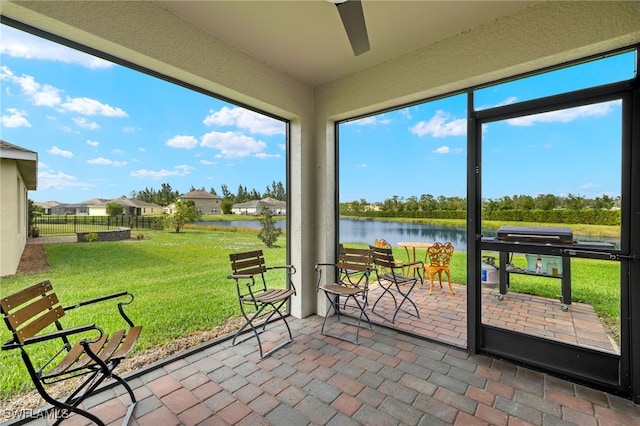 unfurnished sunroom with a water view and ceiling fan