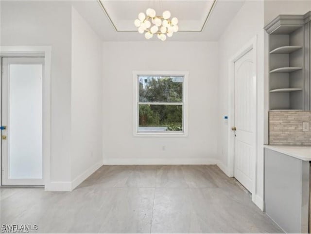 unfurnished dining area with built in shelves and a notable chandelier