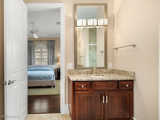 bathroom with ceiling fan, crown molding, vanity, and wood-type flooring