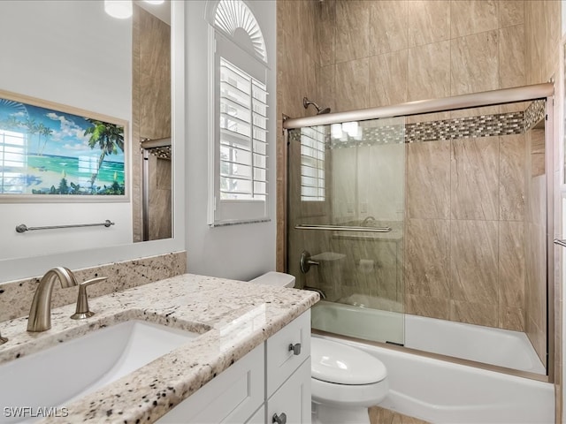 full bathroom with toilet, vanity, and combined bath / shower with glass door