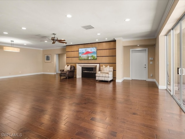 unfurnished living room featuring dark hardwood / wood-style floors, ceiling fan, and crown molding