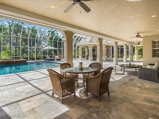 view of swimming pool featuring an in ground hot tub, a patio, glass enclosure, and ceiling fan