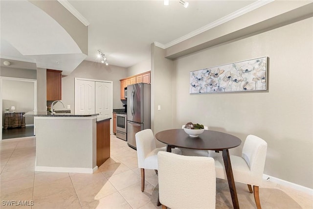 dining area featuring light tile patterned floors, baseboards, and ornamental molding