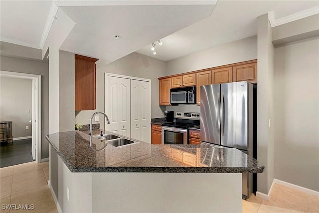 kitchen with brown cabinets, crown molding, light tile patterned floors, appliances with stainless steel finishes, and a sink