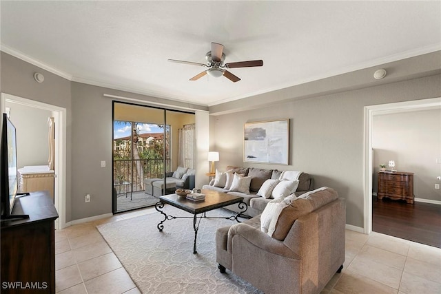 living room featuring a ceiling fan, light tile patterned flooring, crown molding, and baseboards