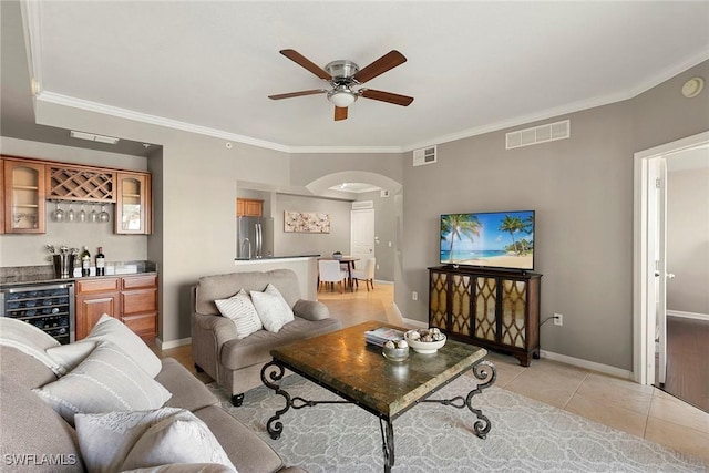 living room featuring arched walkways, wine cooler, light tile patterned floors, and visible vents