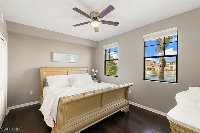 bedroom with dark wood-style floors, ceiling fan, and baseboards