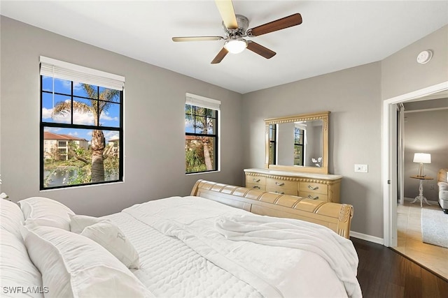 bedroom featuring ceiling fan, baseboards, and wood finished floors