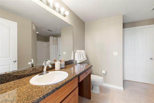 full bathroom featuring toilet, vanity, baseboards, tile patterned floors, and walk in shower