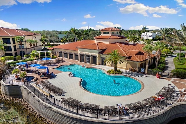 community pool featuring a residential view, fence, and a patio