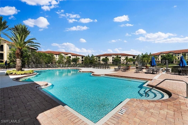 community pool featuring a patio and fence