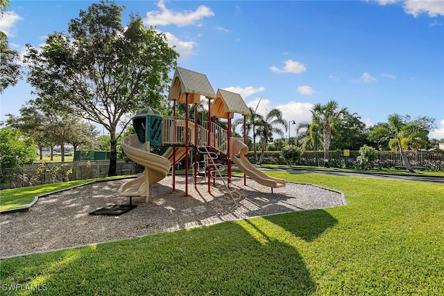 community jungle gym with a lawn and fence