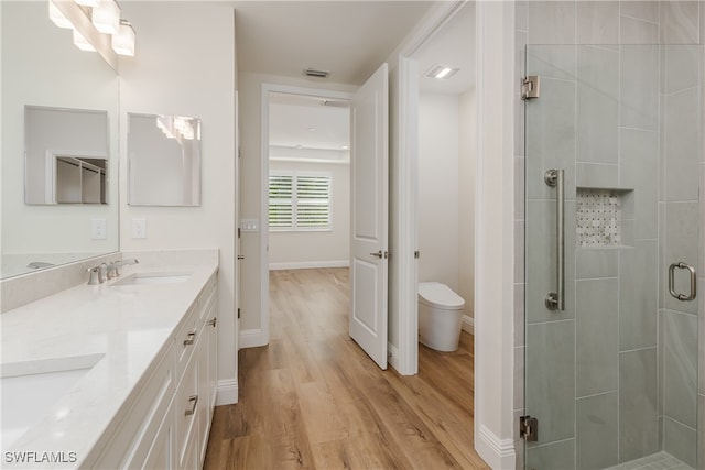 bathroom featuring hardwood / wood-style floors, vanity, an enclosed shower, and toilet