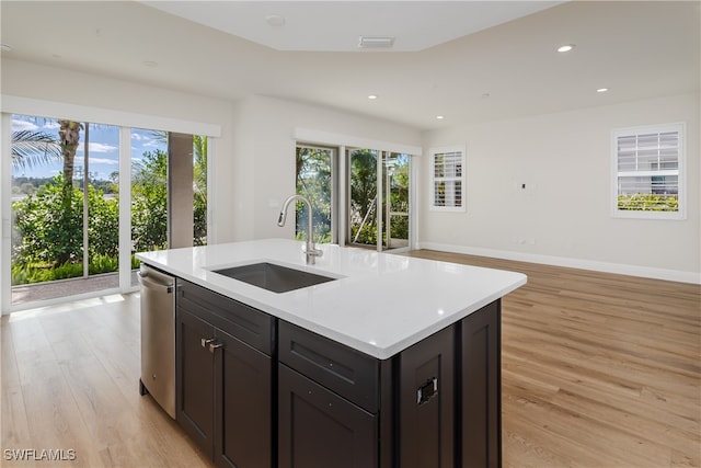 kitchen featuring a kitchen island with sink, sink, and light wood-type flooring