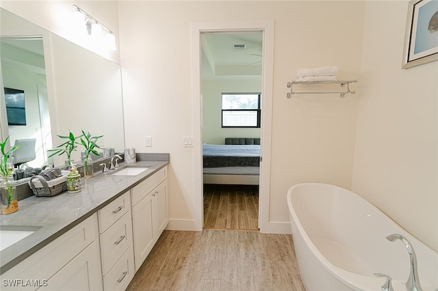 bathroom featuring a tub to relax in, vanity, and hardwood / wood-style flooring