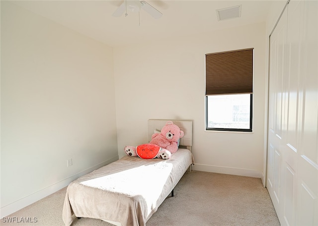 carpeted bedroom with ceiling fan and a closet