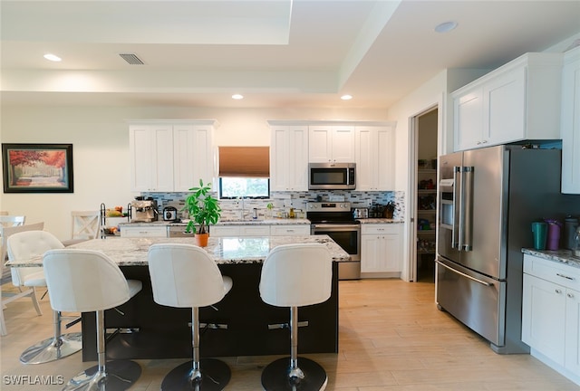 kitchen with a center island, appliances with stainless steel finishes, and white cabinets