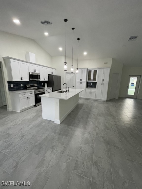 kitchen with stainless steel appliances, sink, an island with sink, white cabinets, and lofted ceiling