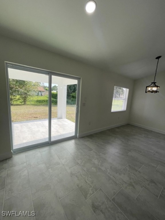 unfurnished room with a chandelier