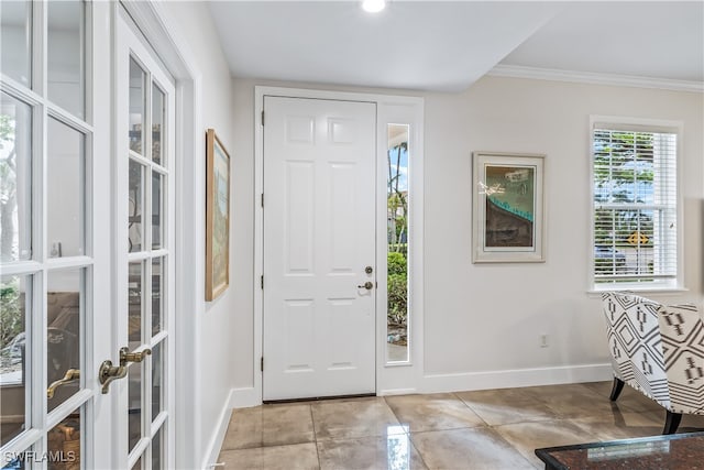 tiled entryway featuring crown molding