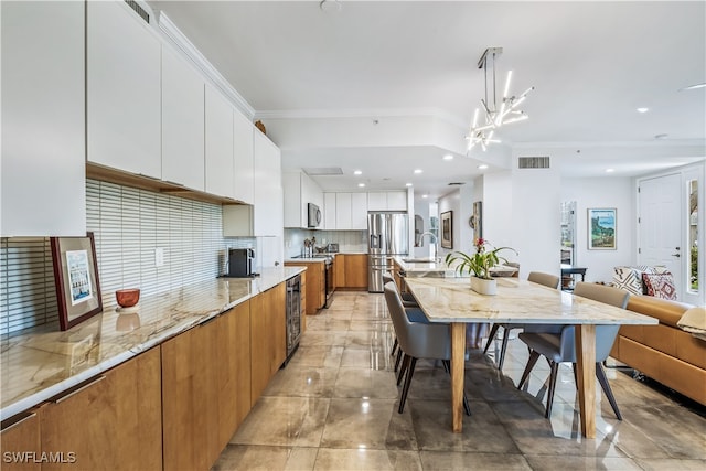 kitchen with white cabinetry, stainless steel appliances, wine cooler, crown molding, and pendant lighting