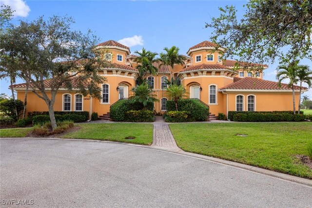 mediterranean / spanish home with a front lawn