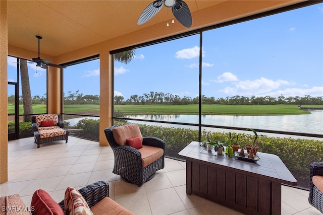 sunroom featuring ceiling fan, a water view, and a wealth of natural light