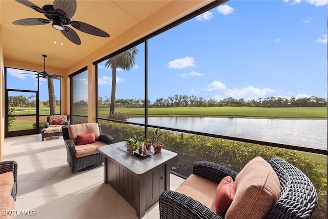 sunroom featuring a water view and ceiling fan