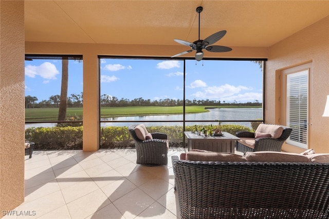 sunroom / solarium with a wealth of natural light, a ceiling fan, and a water view