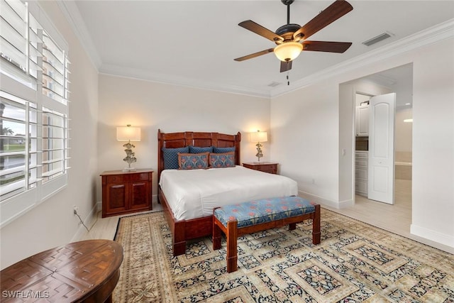 bedroom with wood finished floors, visible vents, baseboards, and ornamental molding