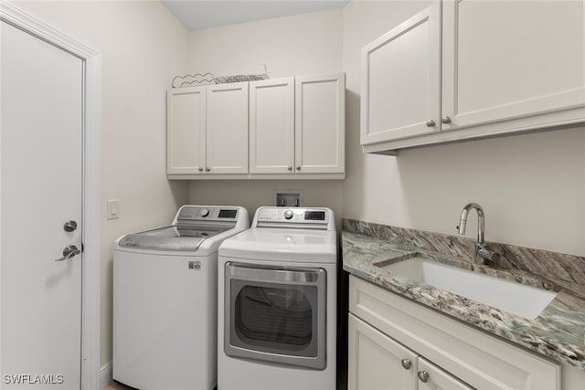 laundry area featuring cabinets, washing machine and dryer, and sink