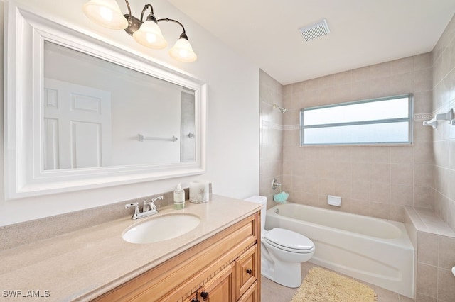 full bathroom with toilet, tiled shower / bath combo, and vanity