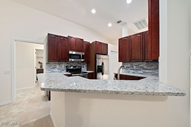 kitchen with kitchen peninsula, light stone counters, and stainless steel appliances