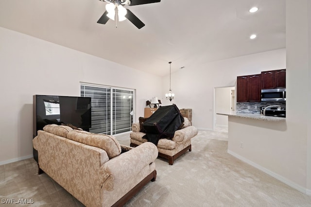 living room featuring ceiling fan with notable chandelier and light carpet