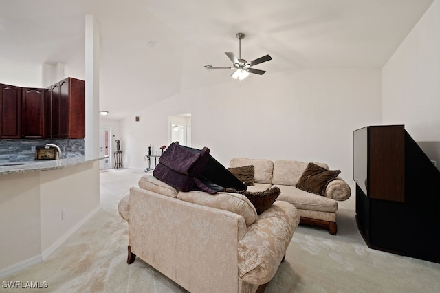 carpeted living room with lofted ceiling, ceiling fan, and sink