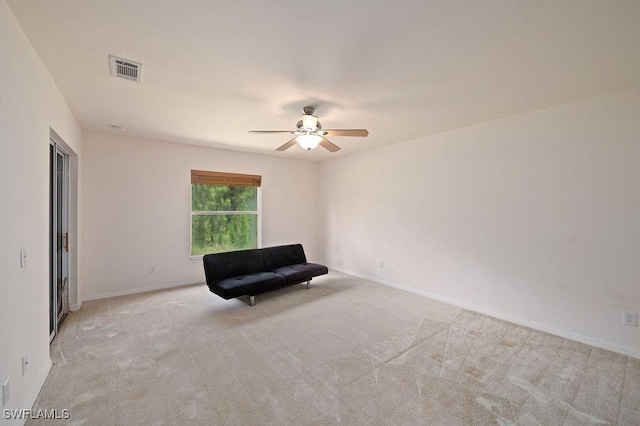 unfurnished room with light colored carpet and ceiling fan