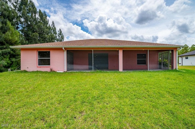 rear view of house featuring a lawn