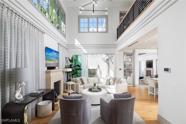 living room with plenty of natural light, wood-type flooring, and a high ceiling